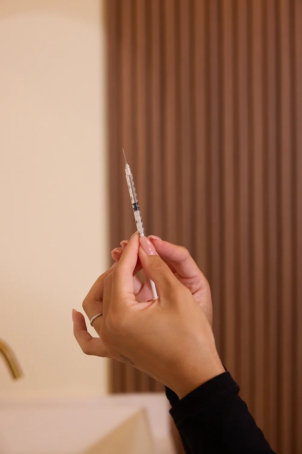 Close-up of hands holding a syringe in the treatment room