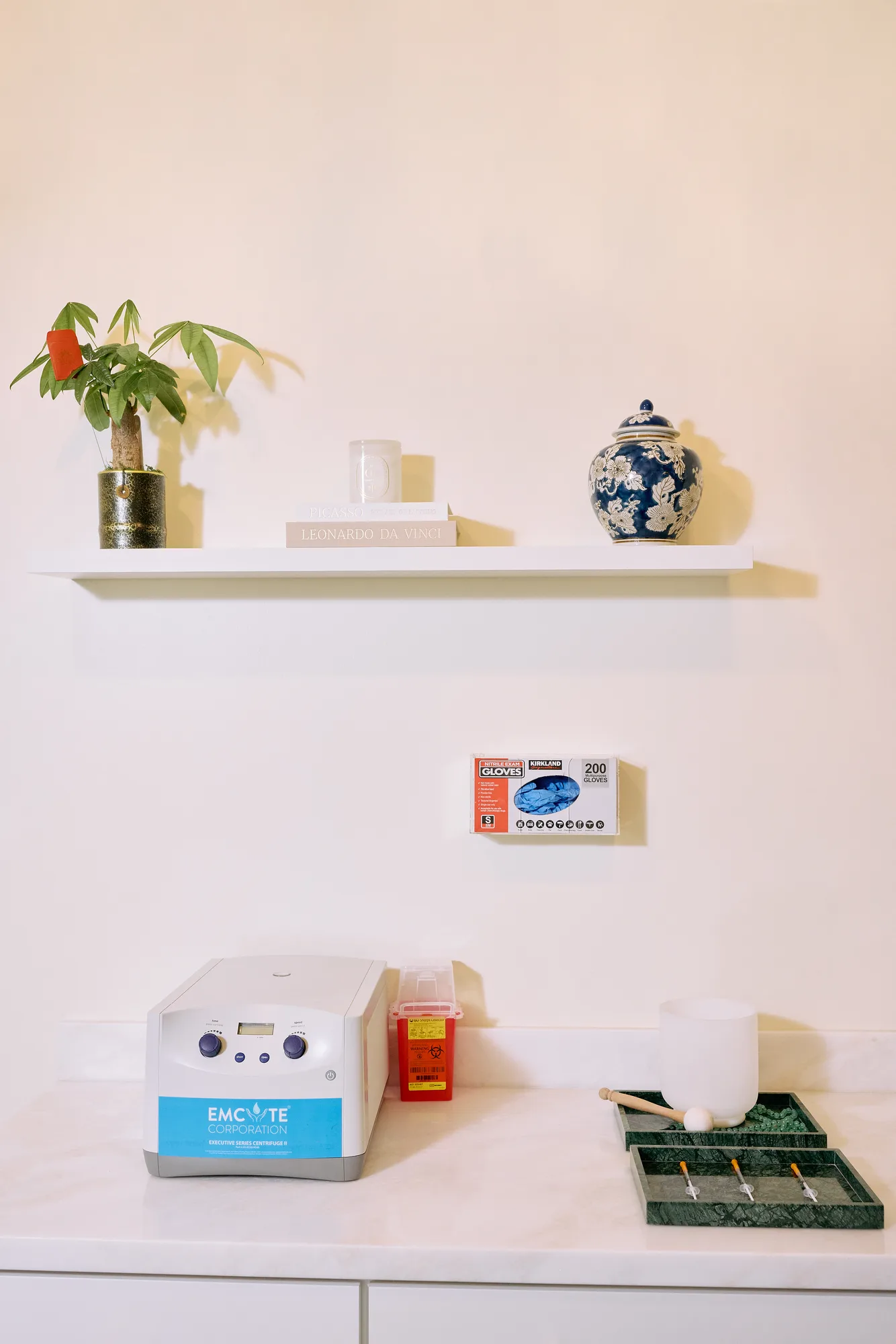 Treatment-room counter with equipment, a singing bowl, and green stone trays